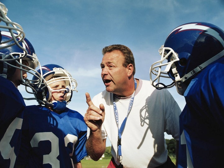 Coach talking to pee wee football team