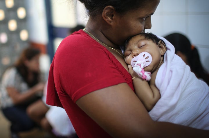 Newborn Ludmilla Hadassa Dias de Vasconcelos, who has microcephaly, is held at Oswald Cruz Hospital on January 26, 2016 in Recife, Brazil. Brazilian authorities have recorded some 4,000 cases of infant microcephaly over the last four months that may be tied to the to mosquito-borne Zika virus.