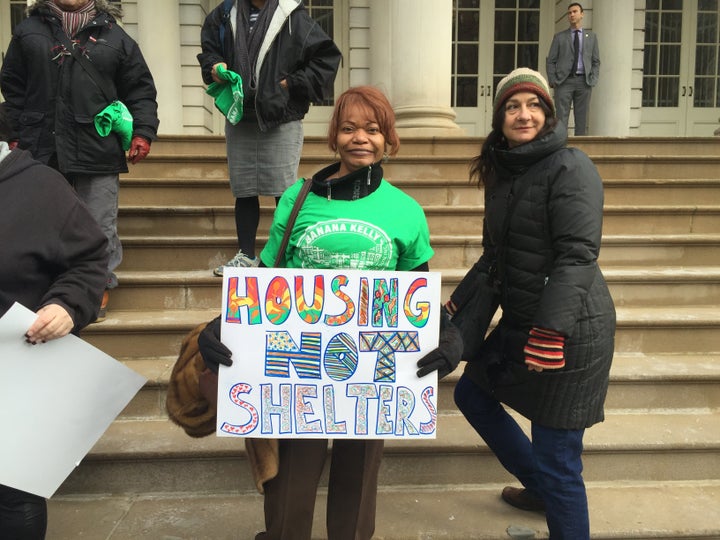 Wanda Silley, whose daughter and granddaughter live in a homeless shelter, holds a sign at the Gaining Ground launch event outside City Hall.