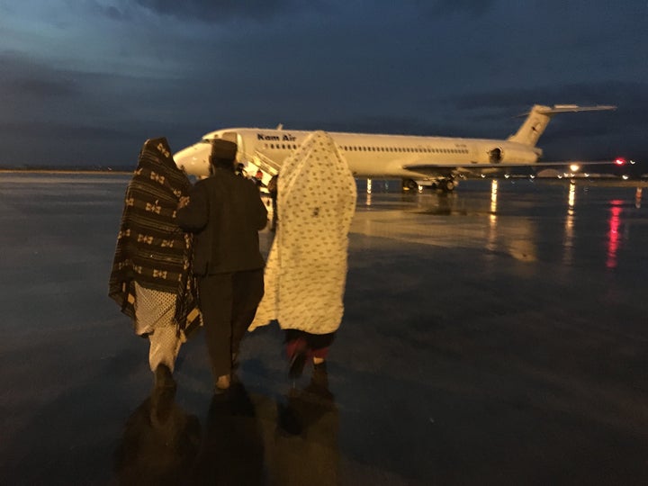 Reza Gul, her brother-in-law, mother, and baby sister walk towards the plane that will transport them to Kabul on Thursday. It was their first time ever flying. 