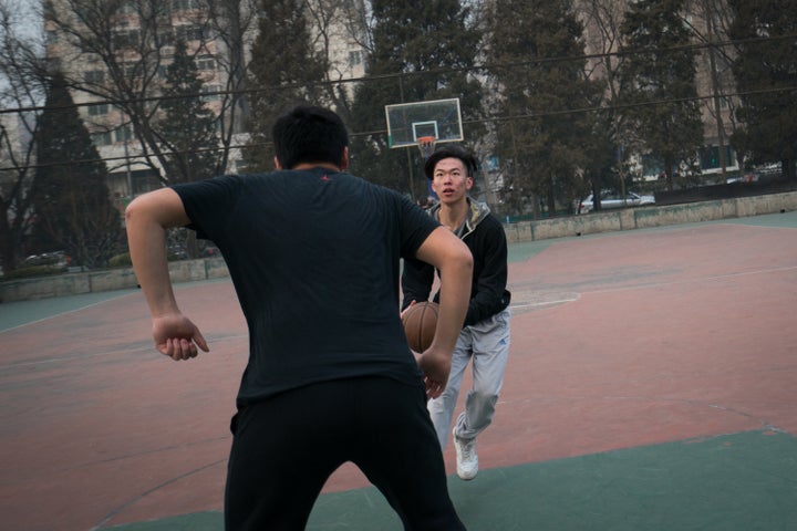 Frank plays basketball with friends near his home in Beijing.