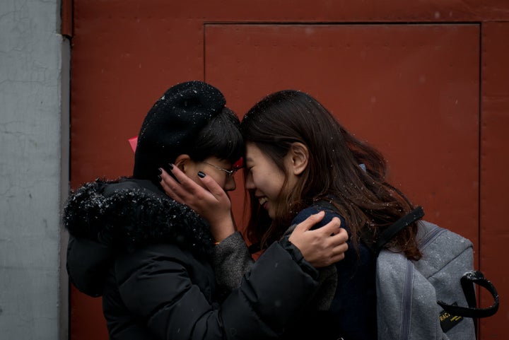 Mayu Yu and Elsie Lau stand outside a marriage registry office in Beijing, where they were refused a marriage license in February 2013.