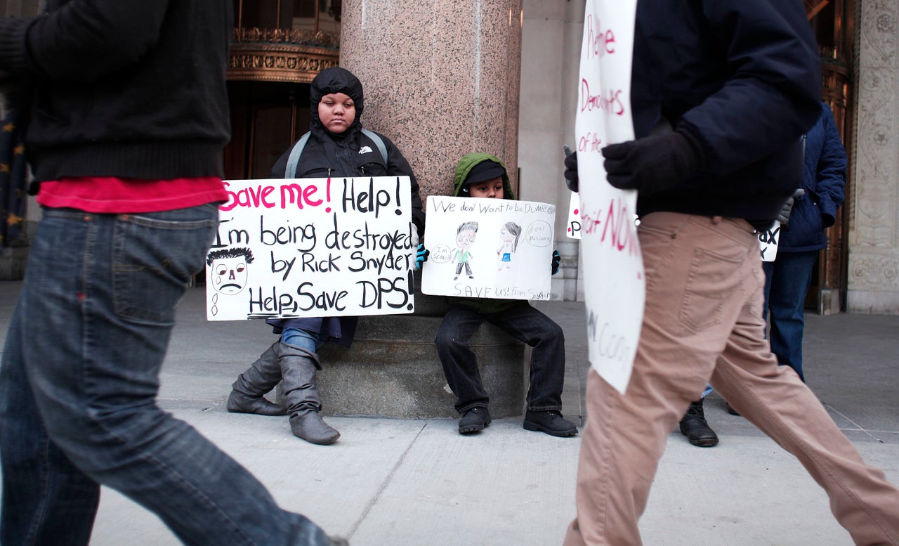 Kids hold signs during a protest at a hearing in Detroit over teacher sickouts that have regularly closed schools since November. Teachers have been calling attention to hazardous conditions in their school buildings as the district faces staggering debts.