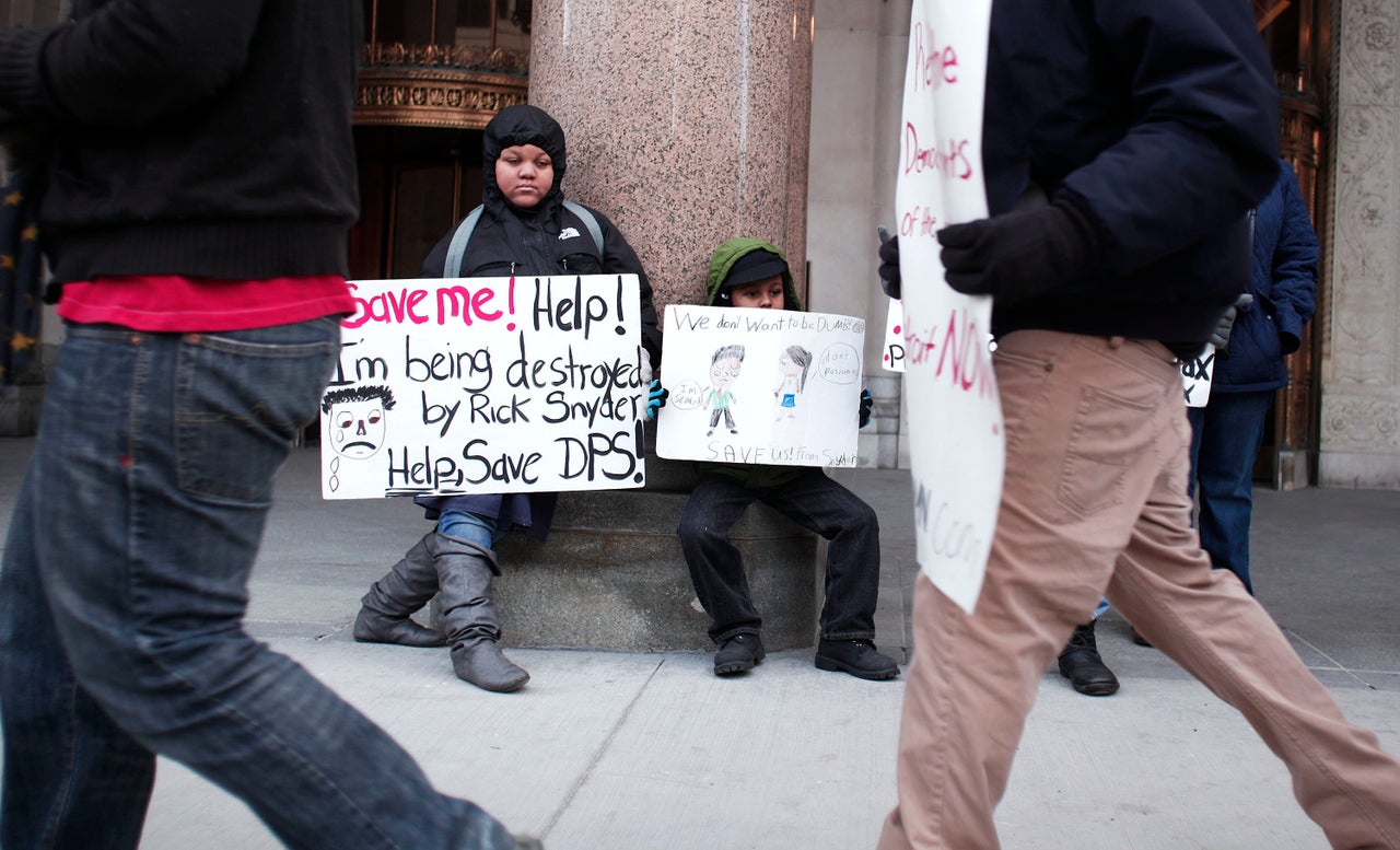 Kids hold signs during a protest at a hearing in Detroit over teacher sickouts that have regularly closed schools since November. Teachers have been calling attention to hazardous conditions in their school buildings as the district faces staggering debts. 