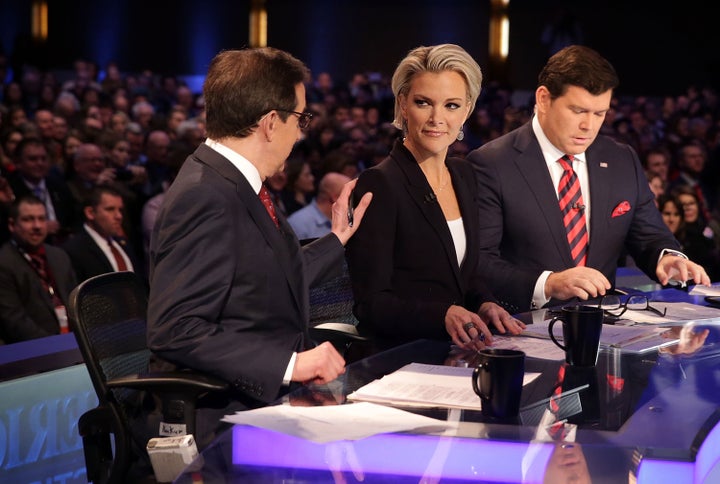 Moderators Chris Wallace (L) pats on the shoulder of Megyn Kelly (2nd L) as they wait with Bret Baier (R) for the beginning o