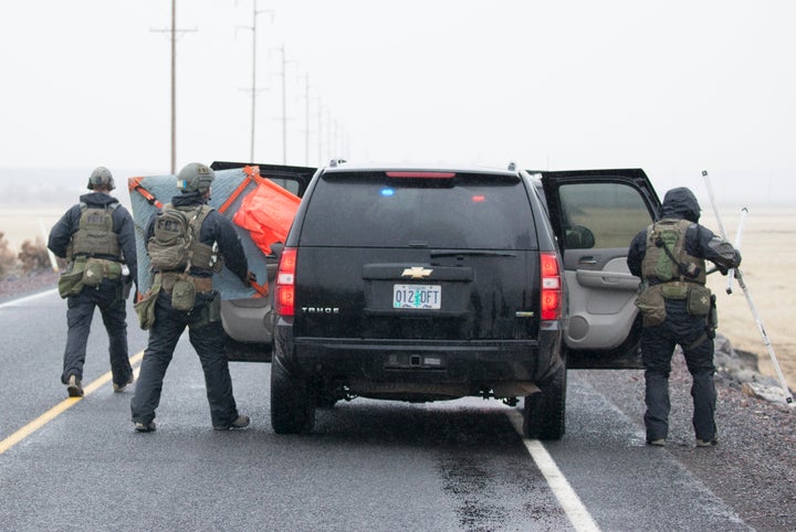 FBI agents remove a road block sign at a checkpoint at the Malheur National Wildlife Refuge in Oregon on Jan.&