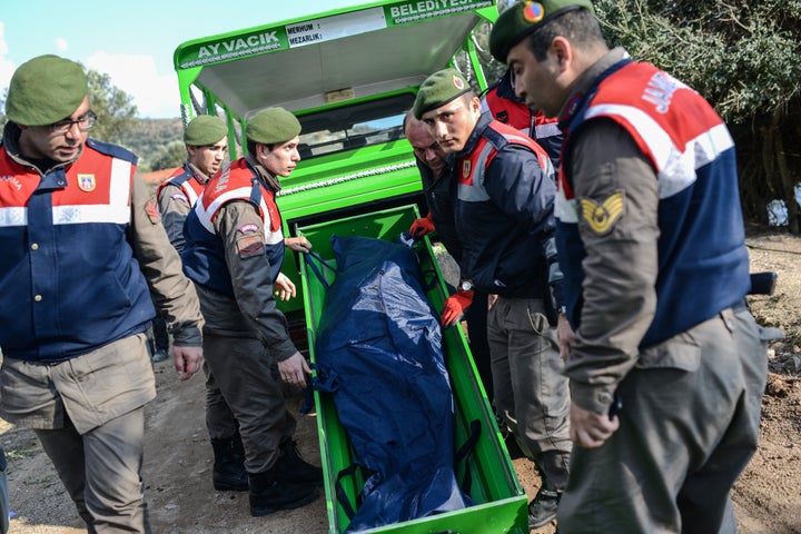 Turkish gendarmes carry the body of a migrant on a beach in Canakkale's Bademli district on January 30, 2016.