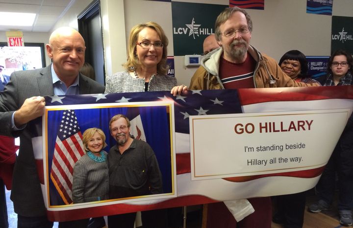 Here's Mark Kelly and Gabby Giffords holding up a banner in support of Hillary Clinton, with a guy whose face is also on the banner. Meta.