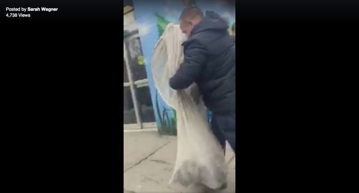 A man appears to hold a net filled with wriggling pigeons after allegedly luring them on a New York City street.