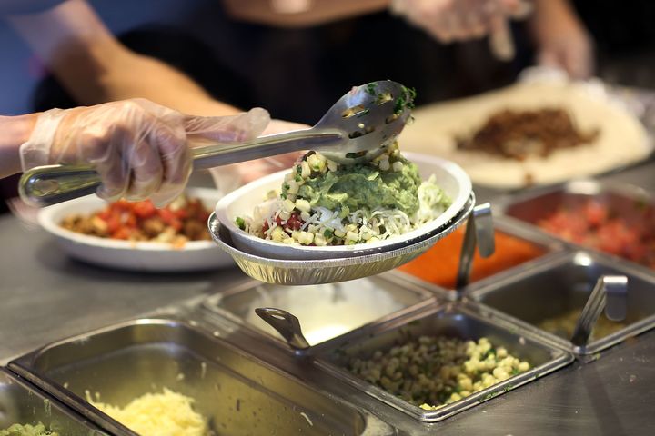 Chipotle restaurant workers fill orders for customers on April 27, 2015, in Miami, Florida. The CDC announced Monday that its investigation into Chipotle's E.coli outbreaks was complete.