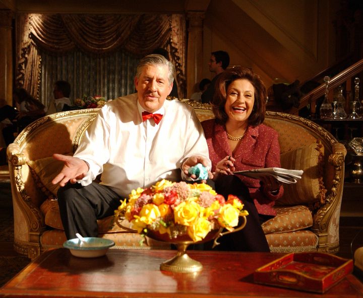 Edward Herrmann as Richard sitting on couch with Kelly Bishop as Emily. (Photo by Patrick Ecclesine/Warner Bros./Getty Images)