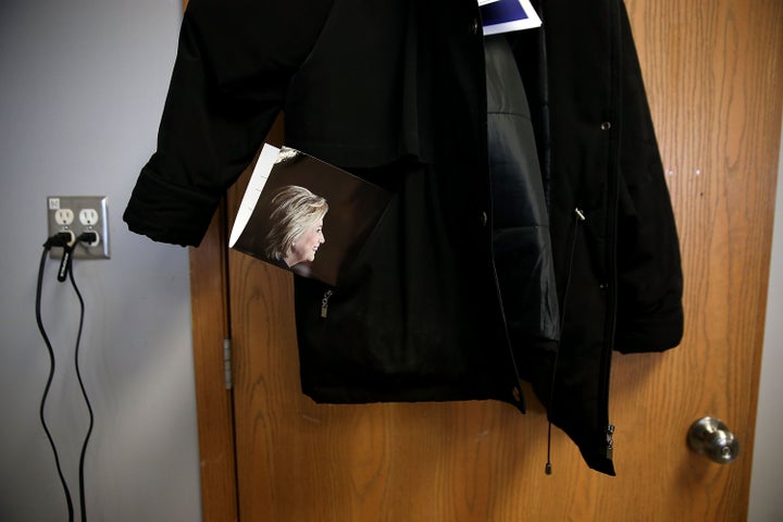 An image of democratic presidential candidate former Secretary of State Hillary Clinton sticks out of a coat pocket that hangs on a door at a campaign office Monday in Ankeny, Iowa.