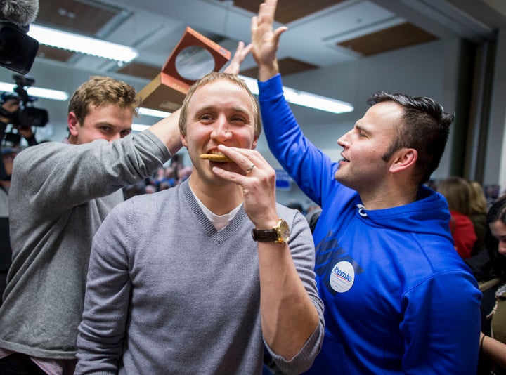 A previous supporter of Democratic presidential candidate Martin O'Malley eats a cookie as he is persuaded to support Democratic presidential candidate Sen. Bernie Sanders during caucus night at the State Historical Society of Iowa, on Monday, Feb. 1, 2016 in Des Moines, Iowa.