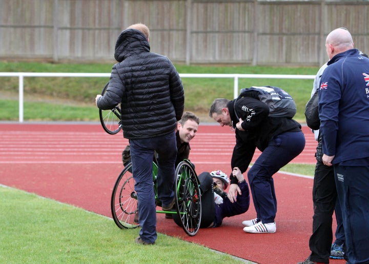 Prince Harry, with his back turned, helps Anna Pollock after she fell over during the UK team trials for the Invictus Games Orlando 2016.