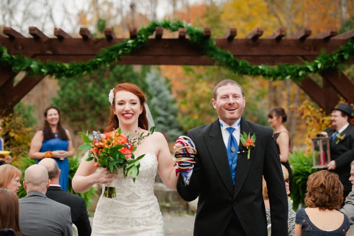 Courtney Weber and her husband, Brian Hoover, walk down the aisle with their hands entwined by the handfasting cords.