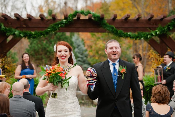 Courtney Weber and her husband, Brian Hoover, walk down the aisle with their hands entwined by the handfasting cords.