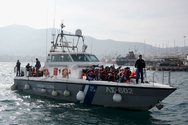 Asylum seekers arrive on a Greek coast guard ship at the port of Lesbos island on Jan. 31, 2016.