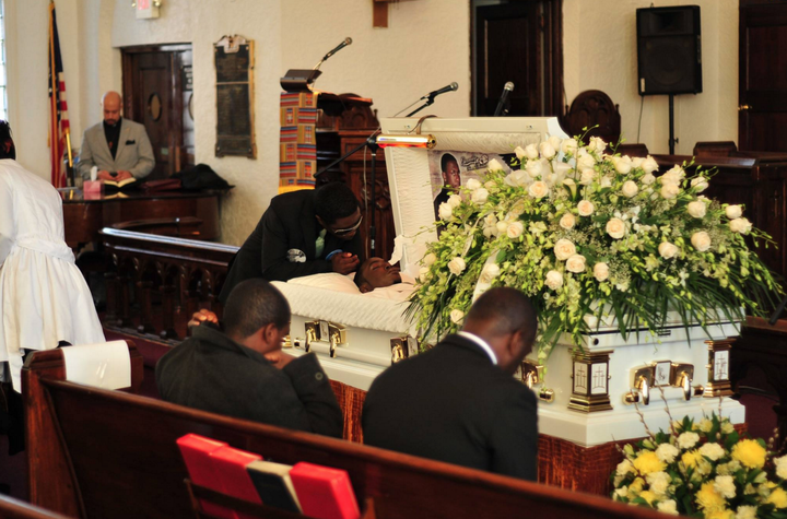 Frank Graham leans over his son's coffin.