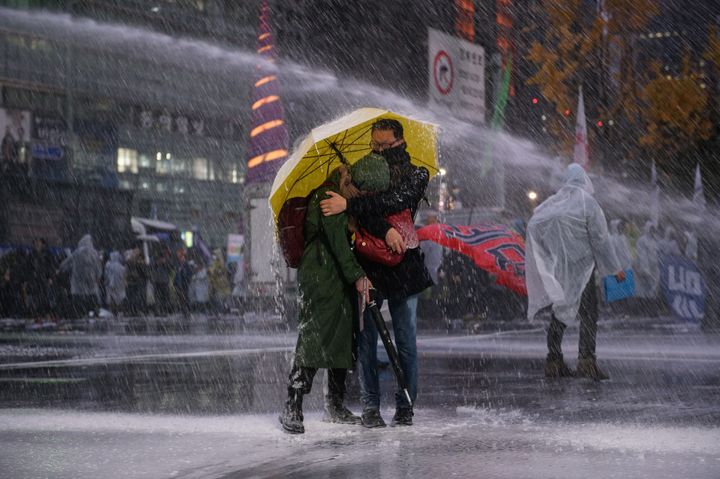 South Korean police had used water cannons and pepper spray on protesters in the past. In this photo, protesters shelter from a water cannon released by riot police in a November protest. One protester remains in a coma after being sprayed with a water cannon that day.