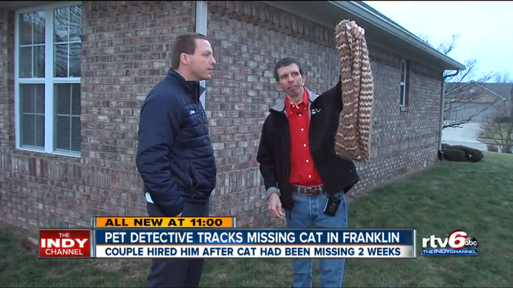 Marmalade's owner holds up a blanket that was used to help find his missing cat.