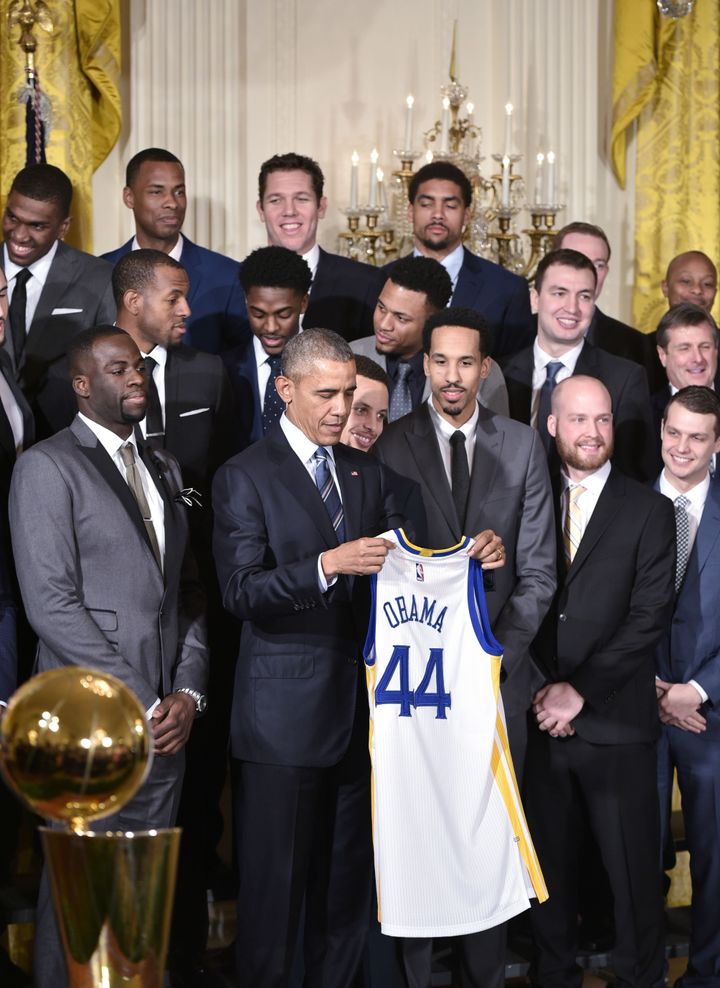 President Barack Obama admires his new jersey from the 2015 NBA champions.
