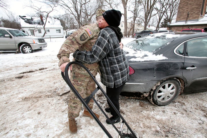 Christine Brown hugs Michigan National Guard Staff Sgt. Steve Kiger of Beaverton, Michigan, after he helped her take bottled water to her car on Jan. 13, 2016, in Flint, Michigan.