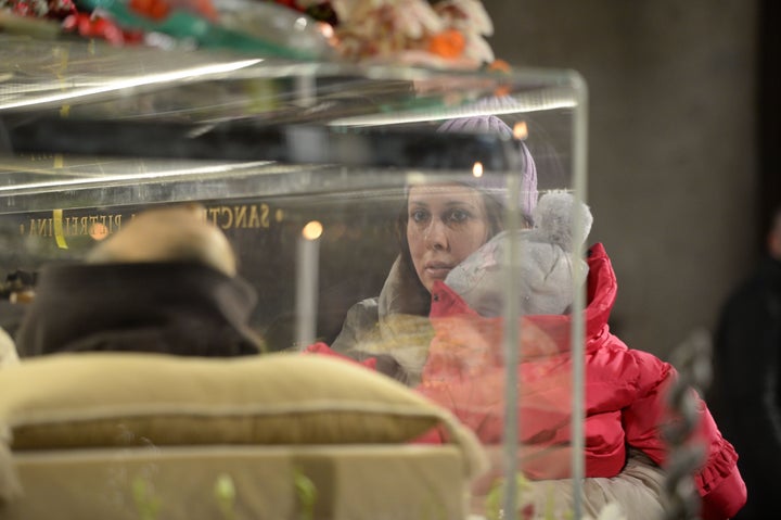 A woman prays in front of the exhumed body of mystic saint Padre Pio in a Catholic church in Rome on February 4, 2016.