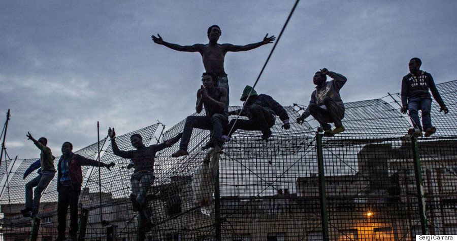 A photo by Sergi Cámara documents an attempt by several men to cross the border fence separating Morocco and Melilla.