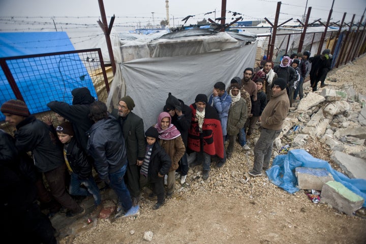 Syrians who fled from their homes due to Russian and Assad Regime forces attacks line up to register to stay in tents on the way between Aleppo and Azez to in Syria on February 6, 2016.