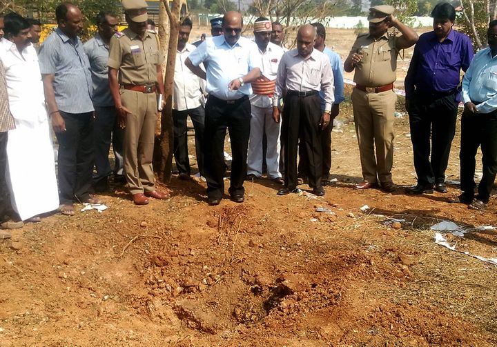 Indian authorities inspect a crater caused by a suspected meteorite that landed on Feb. 7, 2016, killing a bus driver and injuring three others in Vellore, a district in the Indian state of Tamil Nadu.