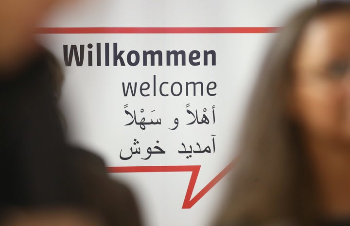 Journalists stand near a sign with "Welcome" written in German, English and Arabic at a new jobs counseling center for migrants and refugees at former Tempelhof Airport during a press preview in Berlin, Germany, in January.