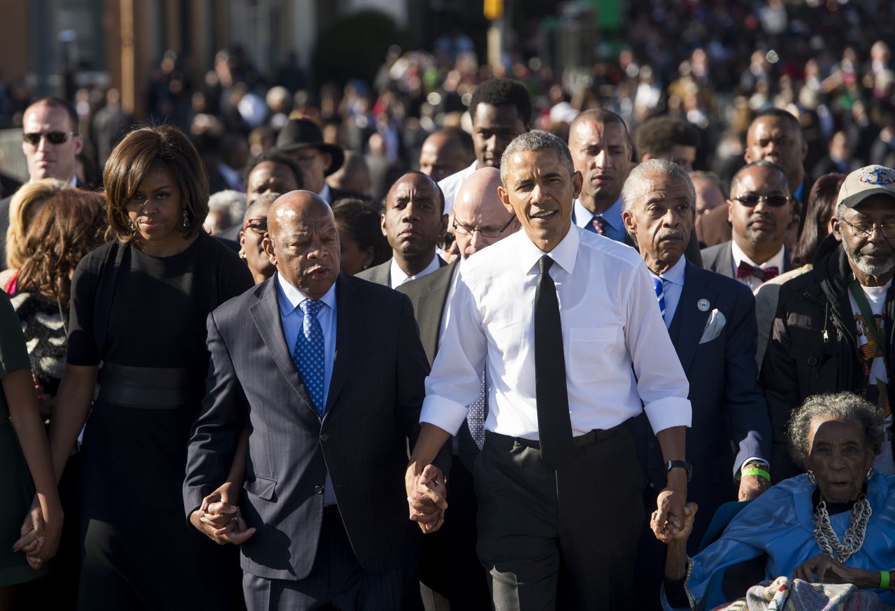 US President Barack Obama walks alongside Amelia Boynton Robinson (R), one of the original marchers, the Reverend Al Sharpton (2nd R), First Lady Michelle Obama (L), and US Representative John Lewis (2nd-L), Democrat of Georgia, and also one of the original marchers, across the Edmund Pettus Bridge to mark the 50th Anniversary of the Selma to Montgomery civil rights marches in Selma, Alabama, March 7, 2015. The event commemorates Bloody Sunday, when civil rights marchers attempting to walk to the Alabama capital of Montgomery to end voting discrimination against African Americans, clashed with police on the bridge.