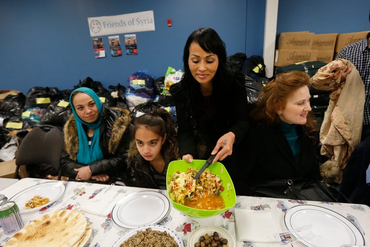 Tina Tran, a refugee who came to Canada from North Vietnam thirty years ago, helps Friends of Syria host a dinner for refugees at the Toronto Port Authority.