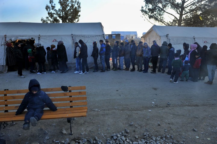 Migrants and refugees line up to receive clothes near Idomeni, Greece, by the Macedonian border.