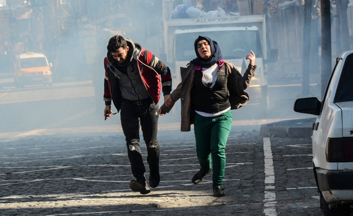 Residents of Diyarbakir in Turkey's Kurd-dominated southeast run for cover from tear gas fired by security forces on Jan. 27.