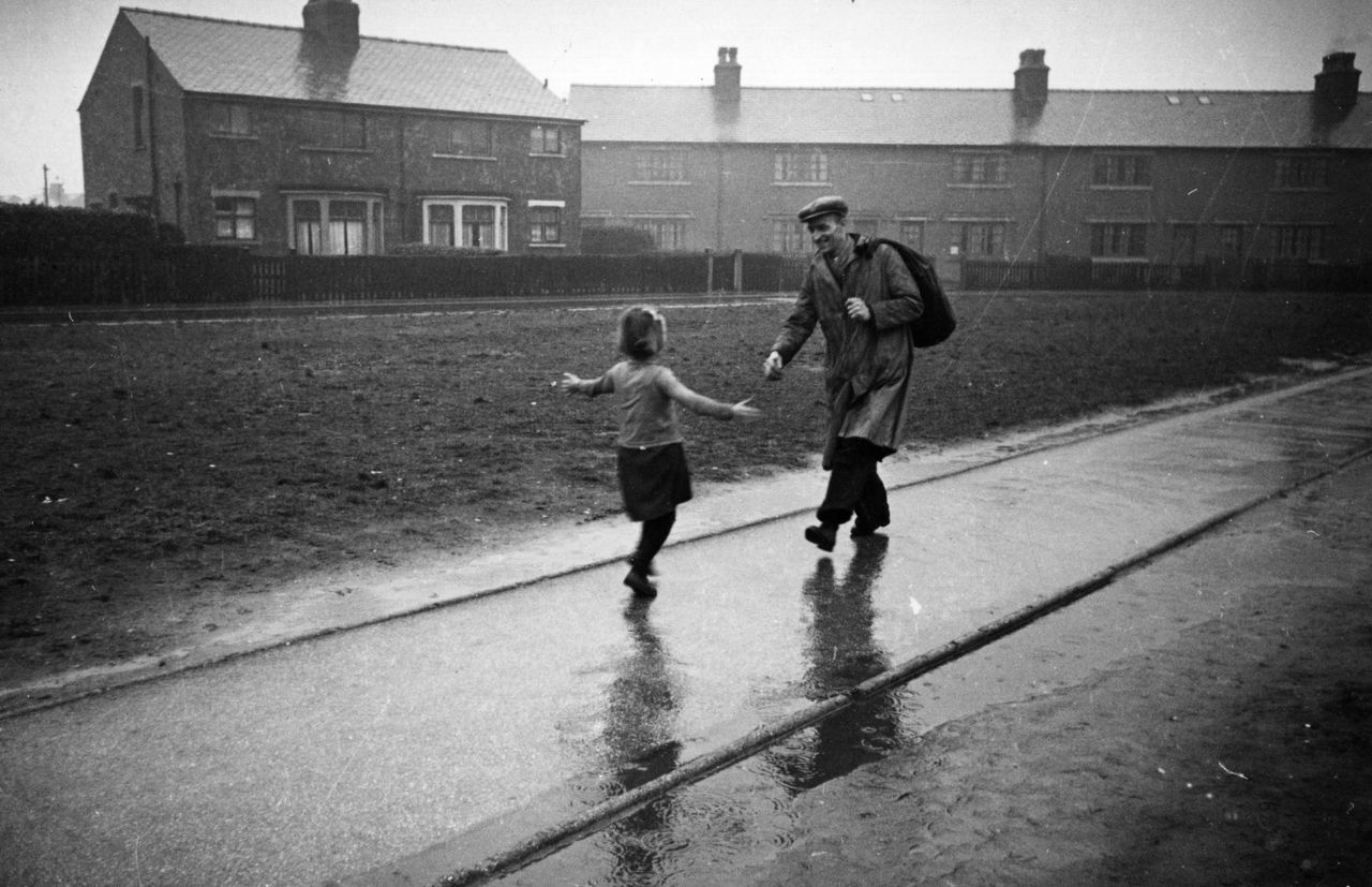 A little girl runs to meet her father on his return from work in March 1942.