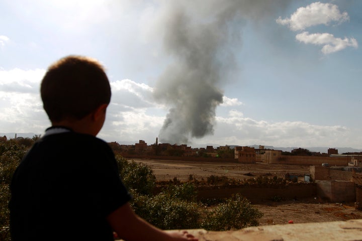 A Yemeni boy watches smoke rise following airstrikes in the capital Sanaa in January. The war in Yemen has seen a surge in child soldiers.