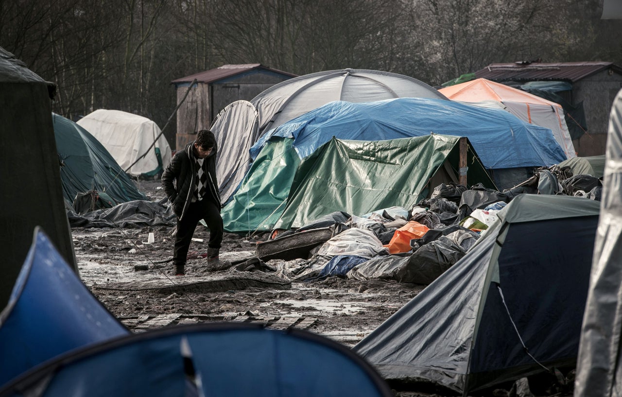 A man walks in the mud near the camp's tents. There are 32 toilets and 48 showers for everyone in the camp to share, Doctors Without Borders reported.