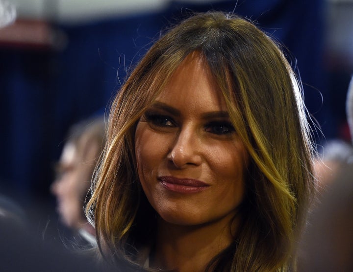 Melania Trump, wife of Republican presidential candidate Donald Trump, looks on as he talks to reporters in the spin room fol