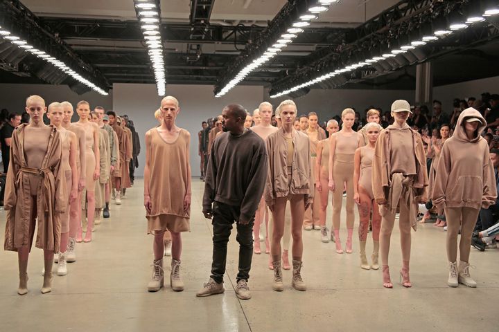 Kanye West poses alongside models wearing khaki hues during the finale of Yeezy Season 2 during New York Fashion Week at Skylight Modern on September 16, 2015 in New York City.