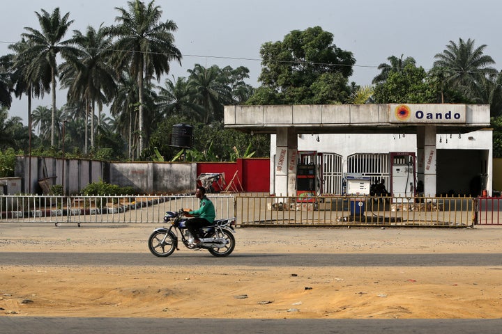 A man rides a motorcycle past a closed gas station in Port Harcourt, Nigeria, on Jan. 14, 2016. Plummeting global oil prices