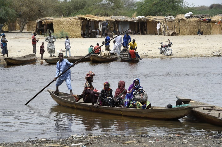 People cross a branch of Lake Chad in April 2015. The lake has shrunk by 90 percent since the 1960s.