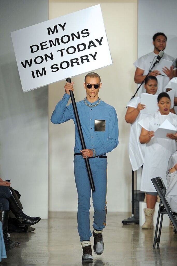 A model carries a sign with the last Facebook status from activist MarShawn M. McCarrel II, who died last week.