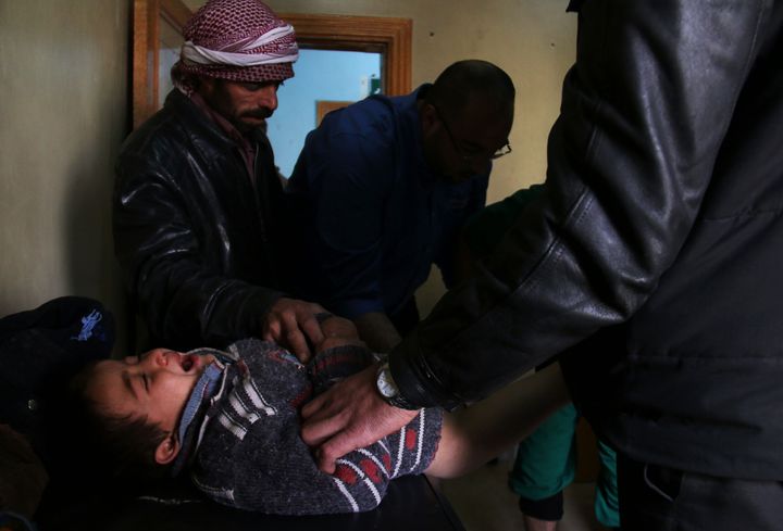 A Syrian child reacts as he receives treatment following reported air strikes in the city of Azaz, on Syria's northern border with Turkey. Dozens of civilians were killed when government-led missiles hit medical centers and schools in rebel-held Syrian towns.