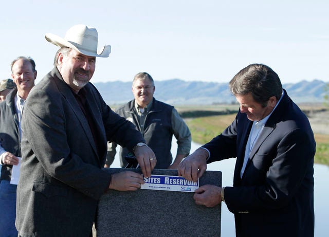 In this photo taken Wednesday March 19, 2014, Republican Rep. Doug LaMalfa, left, and Democratic Rep. John Garamendi, display a bumper sticker supporting the building of a new reservoir in the Sites Valley, during a news conference near Maxwell, Calif.