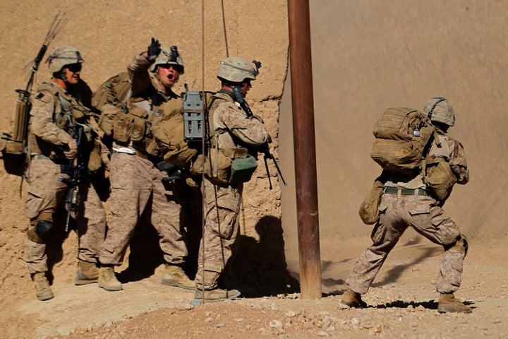 U.S. Marine Sgt. Thomas Brennan shouts to his comrades to keep out of the line of fire from Taliban insurgents during a firefight in Afghanistan, Nov. 1, 2010.