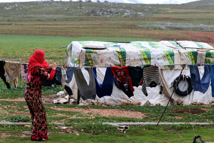 A woman hangs her laundry at an unofficial refugee camp in the Lebanese village of Ibl al-Saki. The lack of Lebanese residency has prevented many women from seeking help from authorities in case they get detained, sent back to their home countries or harassed.