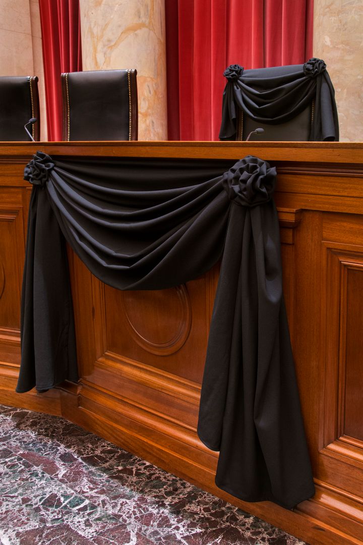 A close-up of Justice Antonin Scalia’s bench chair and the bench in front of his seat.
