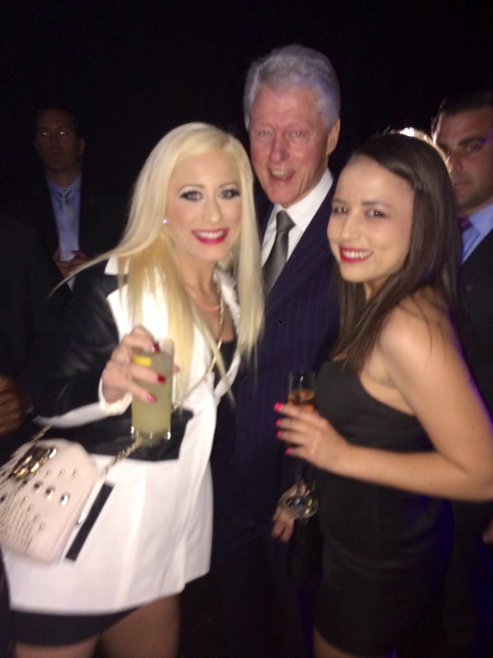 In this photo taken Feb. 28, 2014, Bill Clinton poses with Barbie Girl and Ava Adora, employees at the Moonlight Bunny Ranch Brothel in Carson City, Nevada.