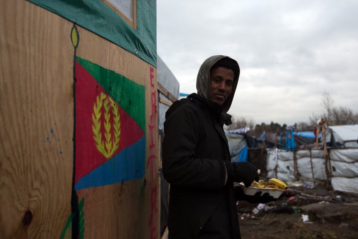 An Eritrean man eats lunch next to a shelter with the Eritrean flag in the camp known as the Jungle in Calais, France, in January 2016. Almost 10 percent of the population are refugees, according to the U.N.